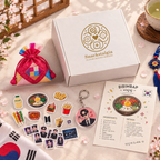 Closed Snackstalgia box with a colourful pouch, food stickers, photocards, a keychain and a bibimbap recipe card.