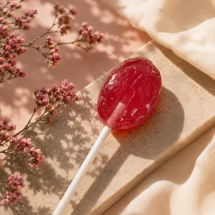 Fruit pop lollipops unwrapped, in grape, orange, strawberry and melon.
