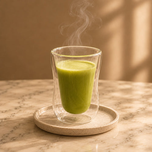 Matcha au lait prepared as a hot drink, a pale green latte in a glass.