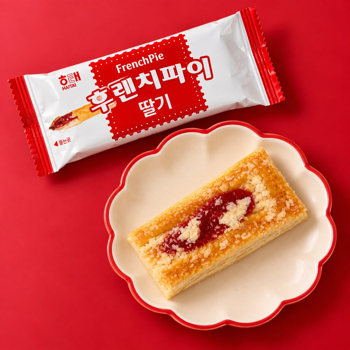 Haitai strawberry French Pie pastry on a scalloped dish beside its red and white wrapper.